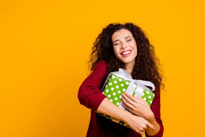 Close up photo beautiful cheerful amazing her she lady hold large package my precious only mine waited long time wearing red knitted sweater pullover clothes outfit isolated yellow background 7-dicas-para-personalizar-a-embalagem-dos-presentes-nesse-final-de-ano